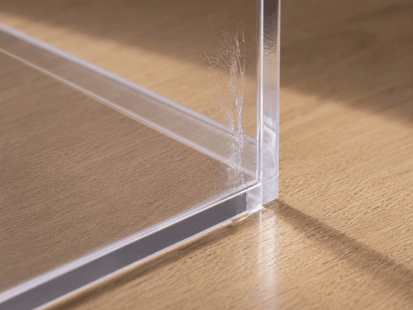 Visible adhesive mark on a transparent acrylic glass surface