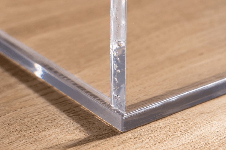 Air bubbles in an uneven acrylic glass adhesive seam