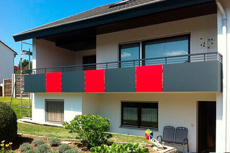 HPL sheets in medium grey and red as balcony cladding from S-Polytec