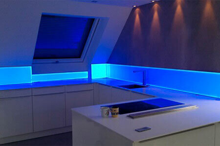 A kitchen unit with acrylic spigot protection with blue backlighting