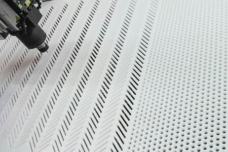 CNC milling of a perforated plate with slotted holes made of white plastic